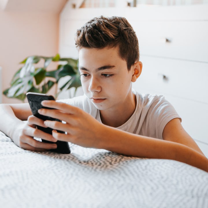 teenager boy using cell home at home in his bedroom