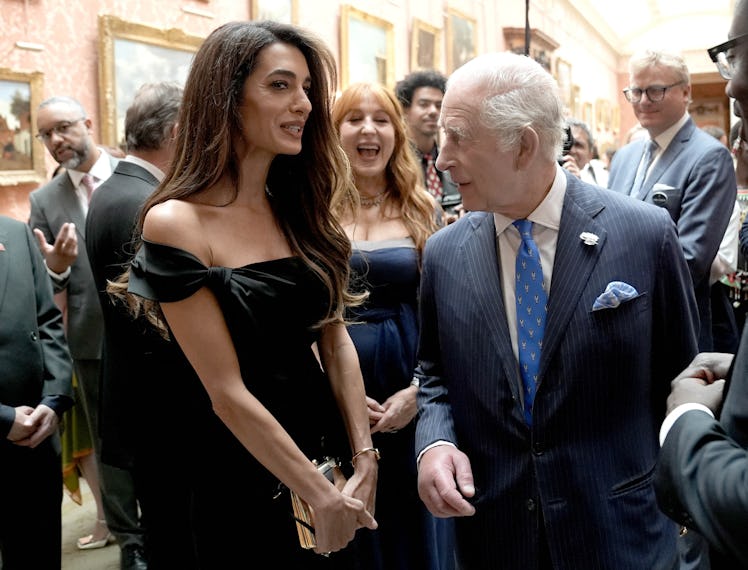 Britain's King Charles III speaks with British Lawyer Amal Clooney during a reception for the winne...