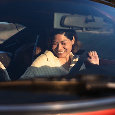 Two friends on vacation traveling Southern California with a vintage car on coastal winding roads.