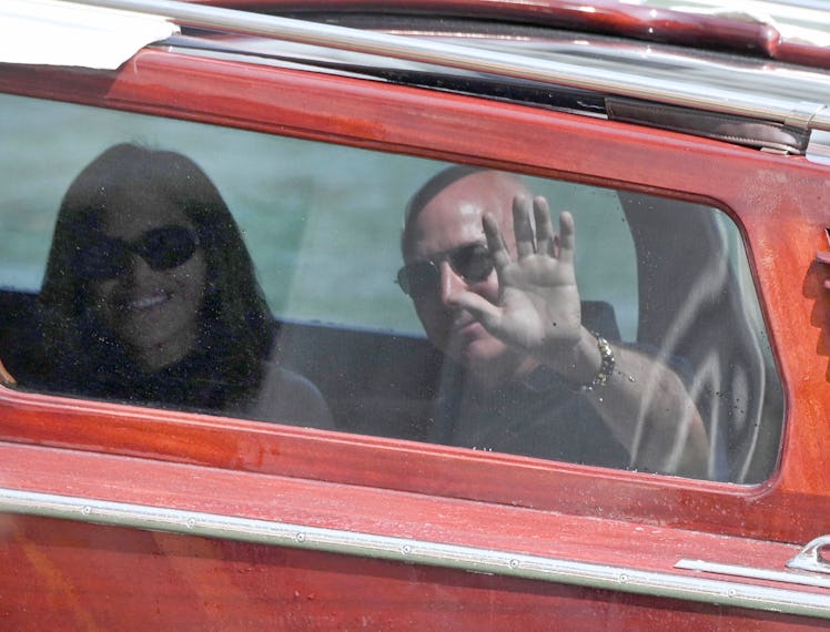 Amazon's founder Jeff Bezos and Lauren Sanchez wave from the taxi-boat as they arrive at the Aman Ho...