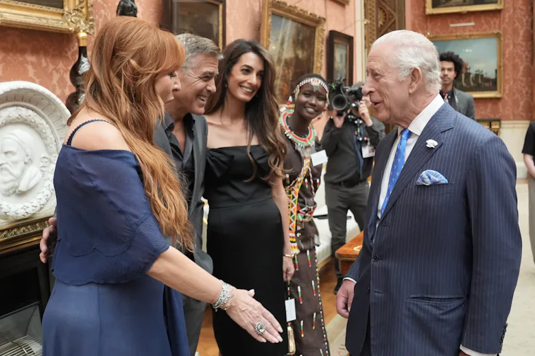 King Charles III speaks with (left to right) Charlotte Tilbury, George Clooney and Amal Clooney duri...