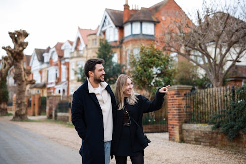 Happy couple walking on the street, holding hands. Front view of romantic couple walking on the stre...