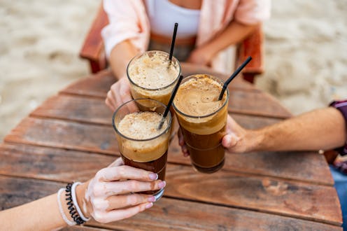 Group of young friends making a toast in a seaside café