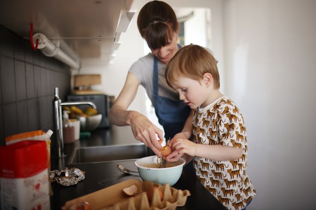 A mother and her son preparing a cake in the kitchen