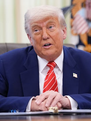 Donald Trump sits at his desk in the Oval Office.