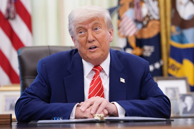 Donald Trump sits at his desk in the Oval Office.