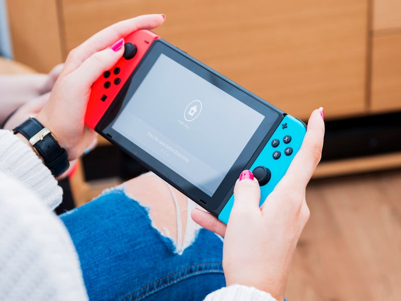 Detail of a young woman playing video games on a Nintendo Switch home console, taken on March 7, 201...