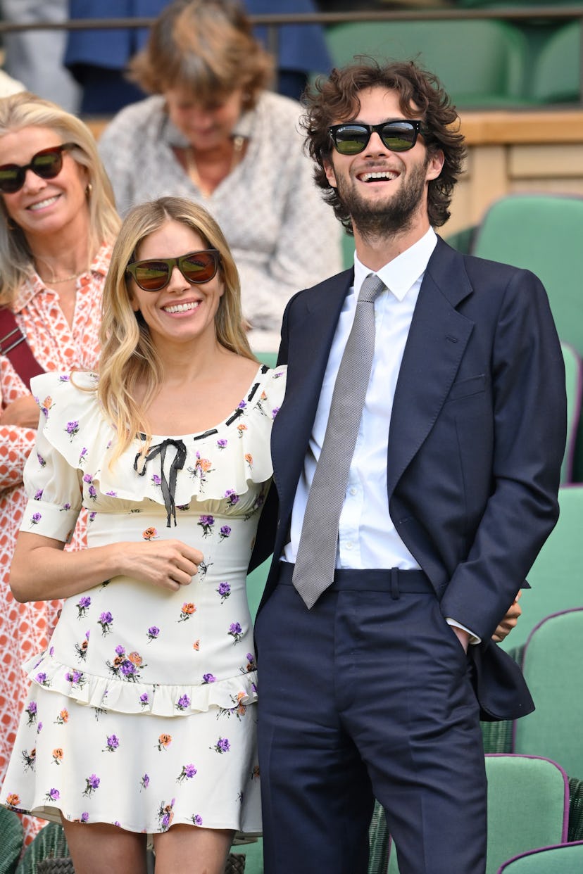 Sienna Miller and Oli Green react to the action court-side on day nine of the Wimbledon Tennis Champ...