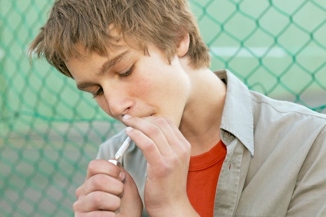 A teenager smoking a cigarette.