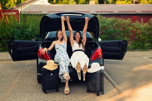 Two young happy beautiful women on vacation arriving on destination.