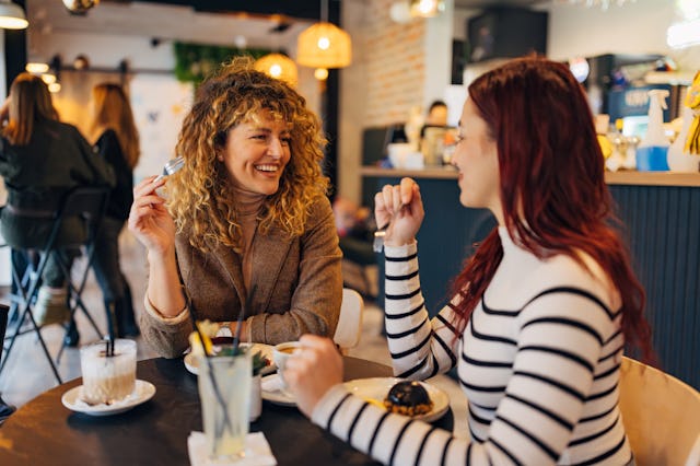 Two female best friends gathered in a coffee shop to drink coffee and eat delicious cakes