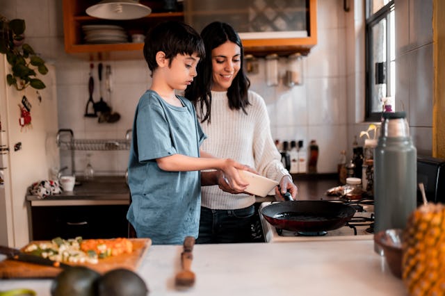 Young boy helping his mom preparing lunch