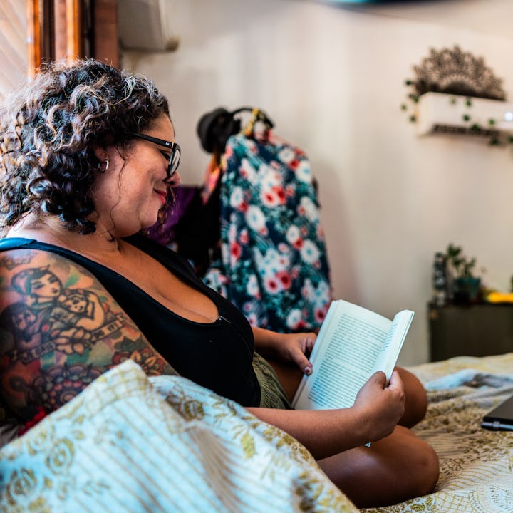 Mid adult woman reading book at home