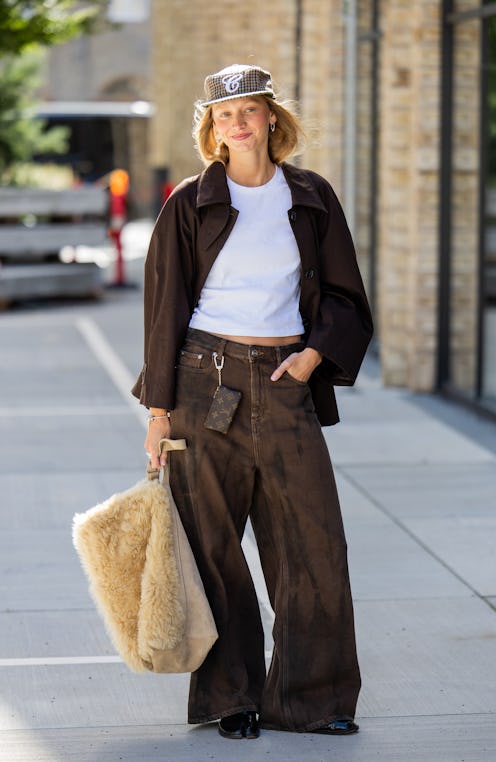 COPENHAGEN, DENMARK - AUGUST 06: Laura Schulte wears cap, brown jacket, wide leg jeans, Louis Vuitto...