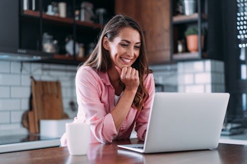 Beautiful young woman having video call at home. Shot of an attractive woman using a laptop for vide...