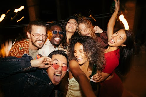 A group of multiracial friends has a great time at the roof nightclub in the summertime. Clubbing, f...