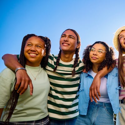 Group of teenager friends embracing and looking up at the sky