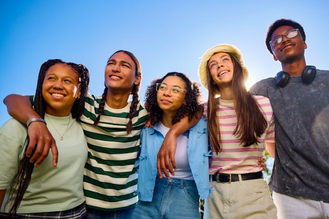 Group of teenager friends embracing and looking up at the sky