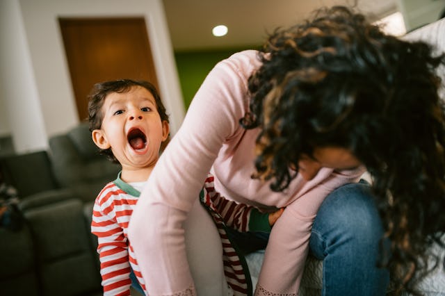 Mother putting pajamas on to her son