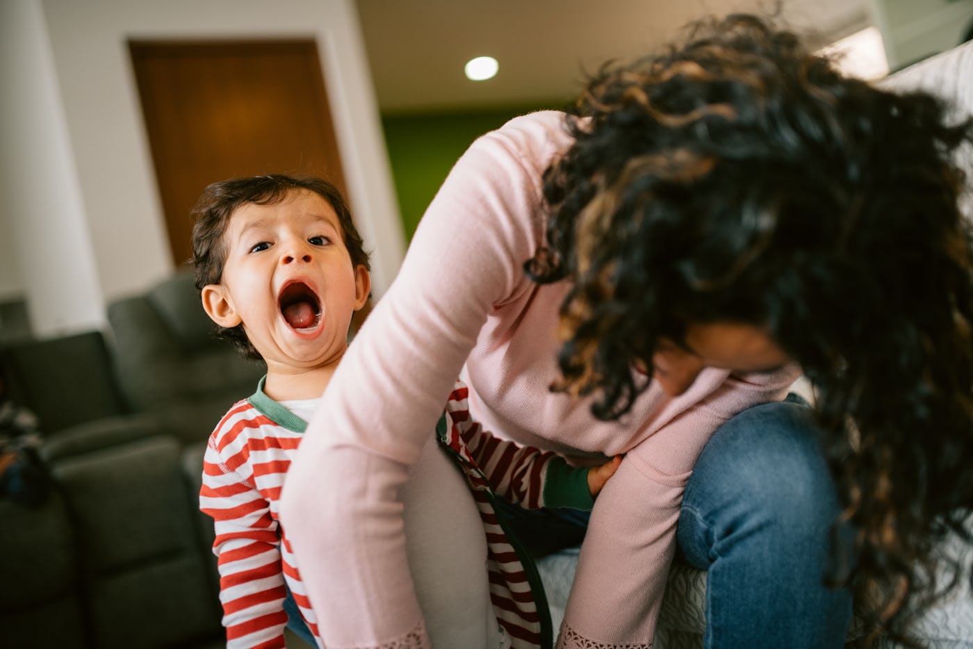 Mother putting pajamas on to her son
