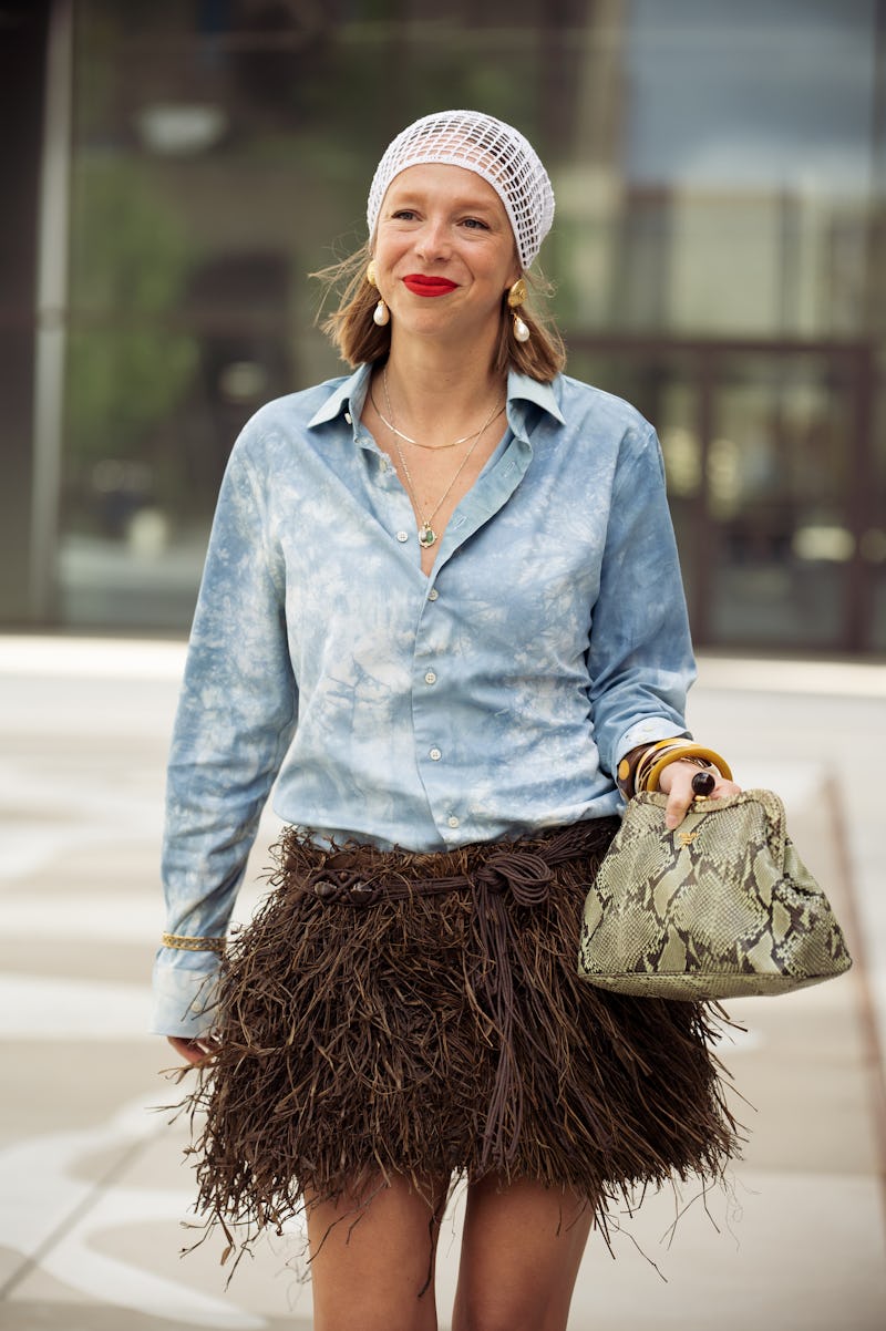 COPENHAGEN, DENMARK - AUGUST 06: Chloe King wears brown fur mini skirt, blue shirt, white head piece...
