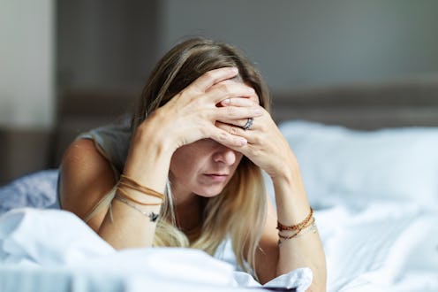 Mid adult woman lying in bed in depression