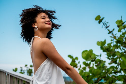 Young woman inhaling enjoying coastline beach