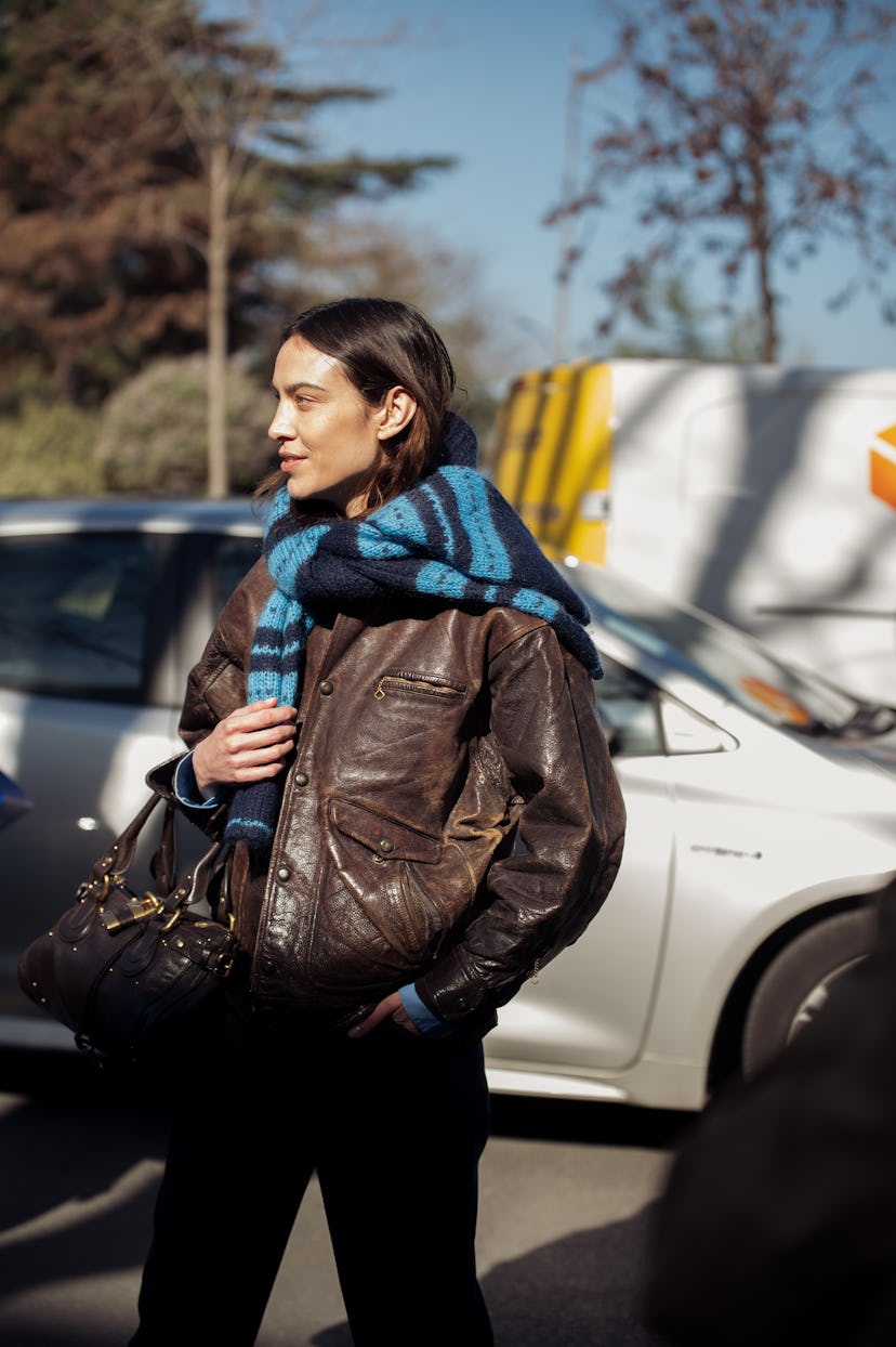 Париж, Франция - 06 марта: Алекса Чунг носит коричневую кожаную куртку, синий и черный полосатый свитер и ...