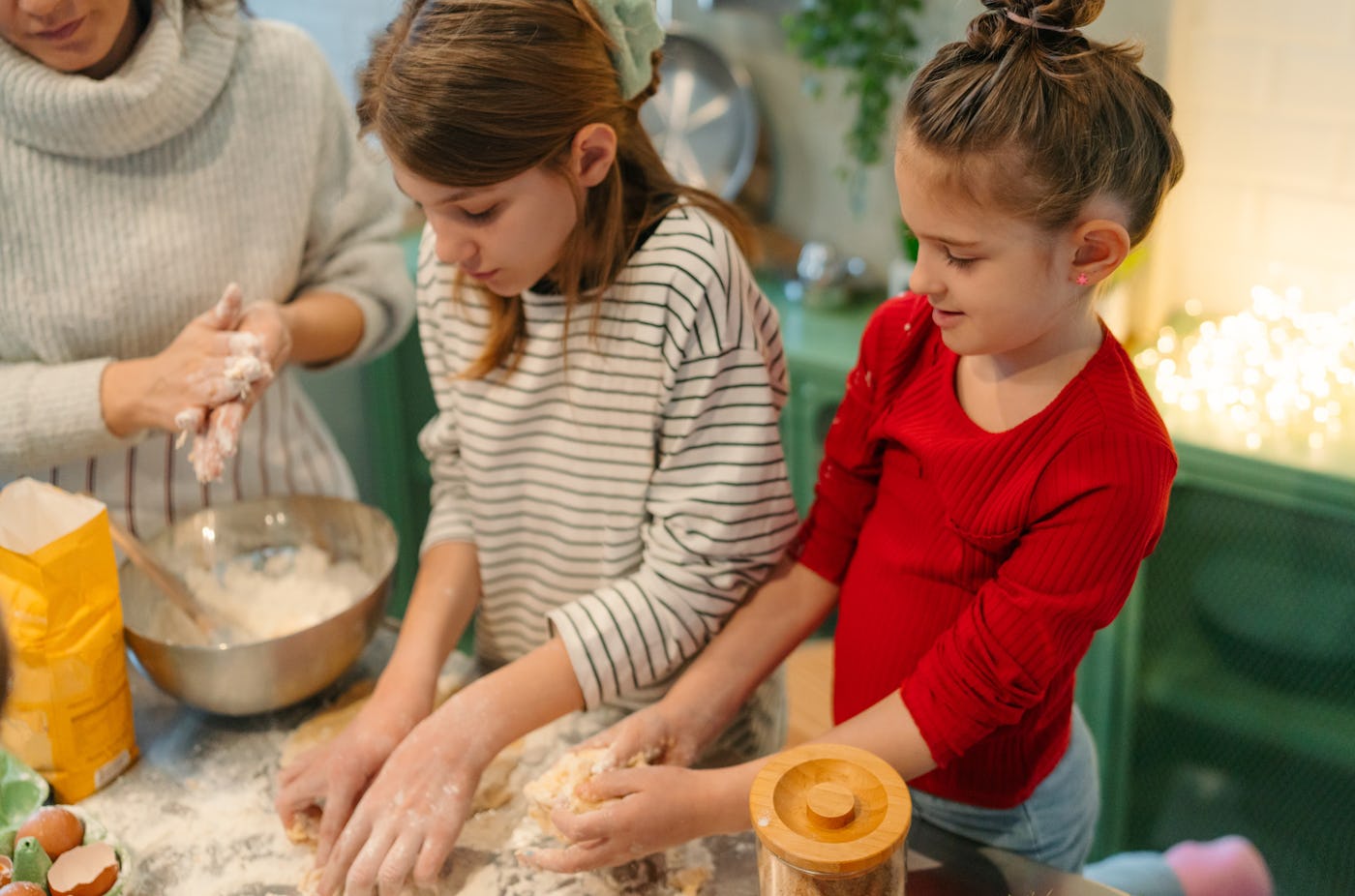 Photo of young girls and their mom having a cooking class at home