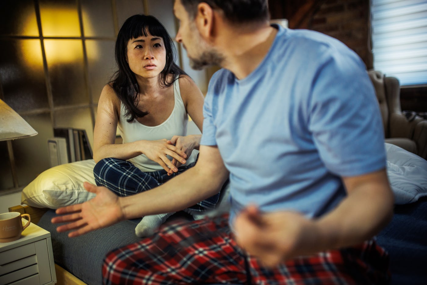 Emotional Couple Expressing Frustration and Upset in Bedroom Argument