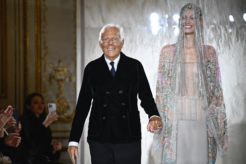TOPSHOT - Italian designer Giorgio Armani acknowledges the applause with Latvian model Agnes Zogla a...