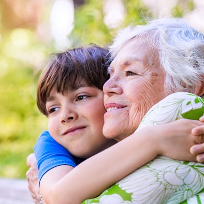 A happy boy hugging his grandmother.