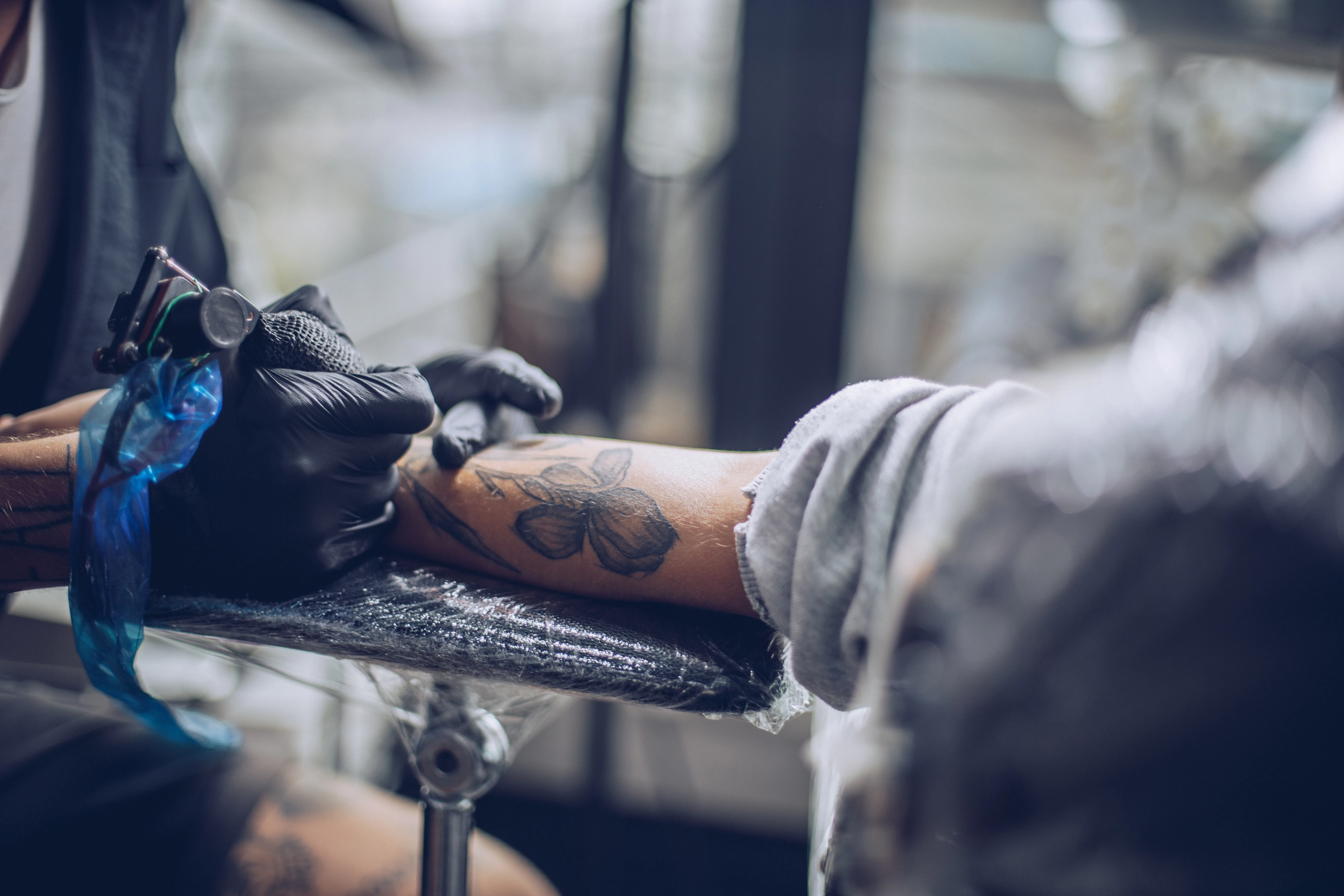 Artist making tattoo on customer's hand in studio