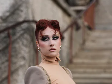 Chappell Roan with a french roll inspired hairstyle on stairs in paris
