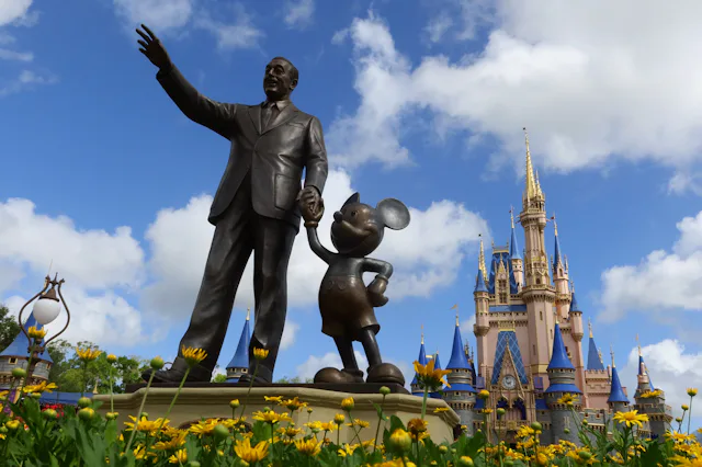 ORLANDO, FL - APRIL 3: A statue of Walt Disney and Mickey Mouse stands in a garden in front of Cinde...