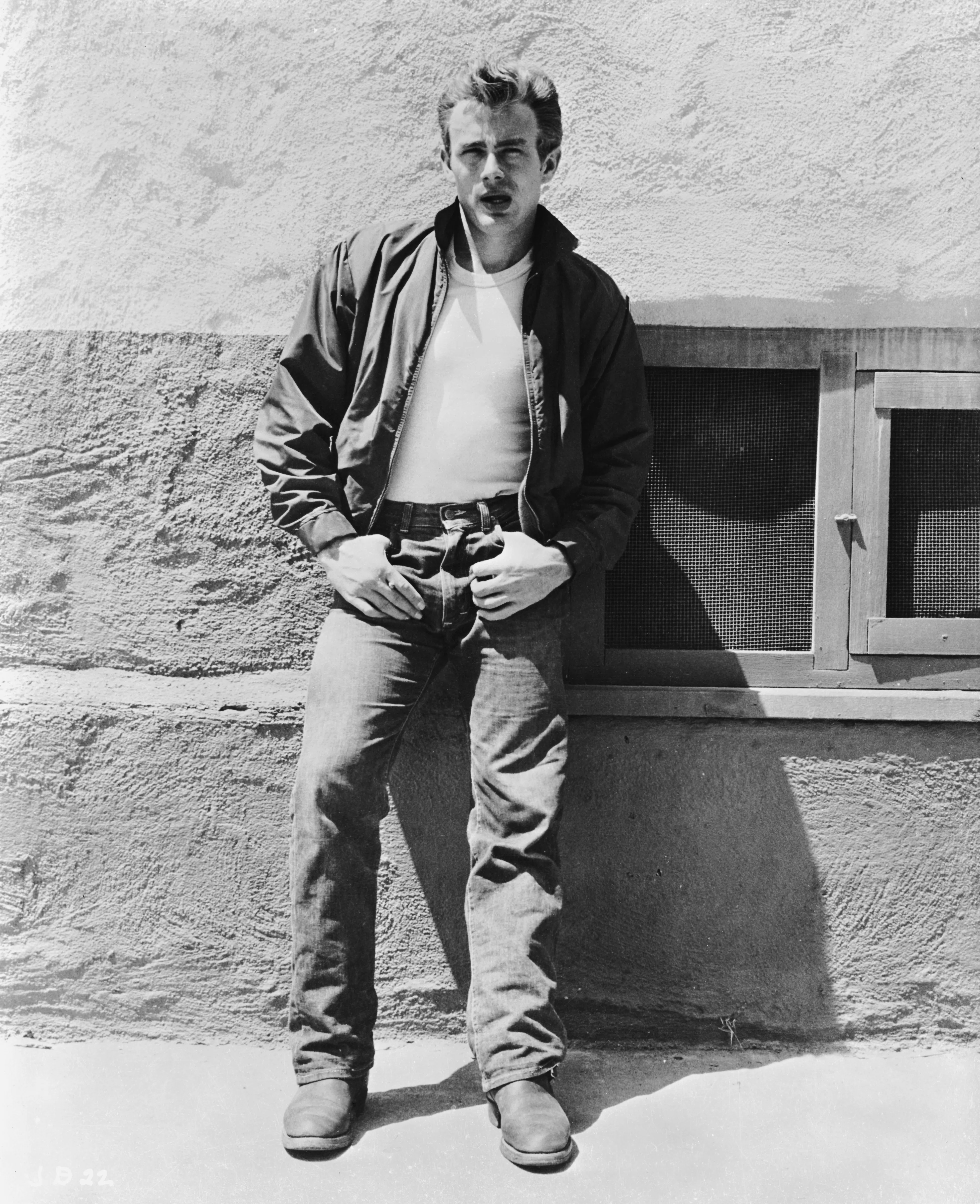 American actor James Dean (1931 - 1955) leans against a wall on the set of director Nicholas Ray's c...