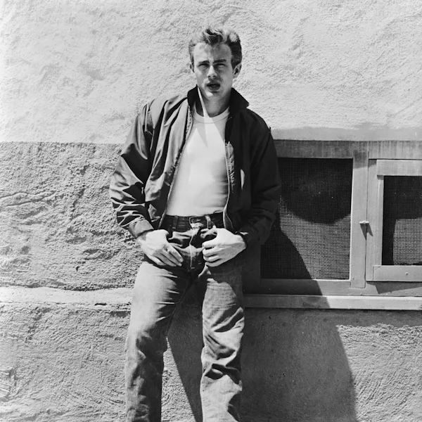 American actor James Dean (1931 - 1955) leans against a wall on the set of director Nicholas Ray's c...