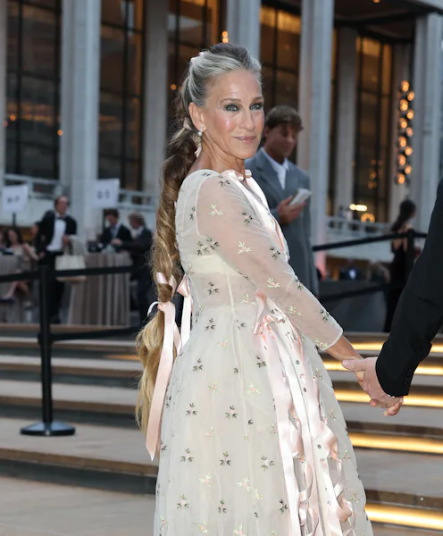 Sarah Jessica Parker at Lincoln Center, standing on the steps with a long braided ponytail