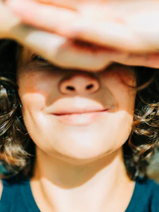 Woman shielding eyes from sun feeling happy