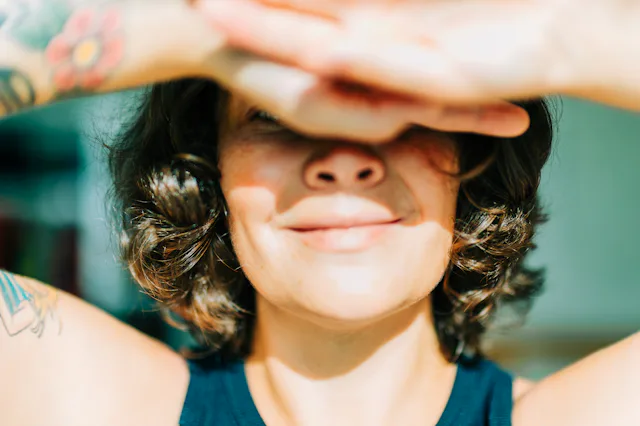 Woman shielding eyes from sun feeling happy