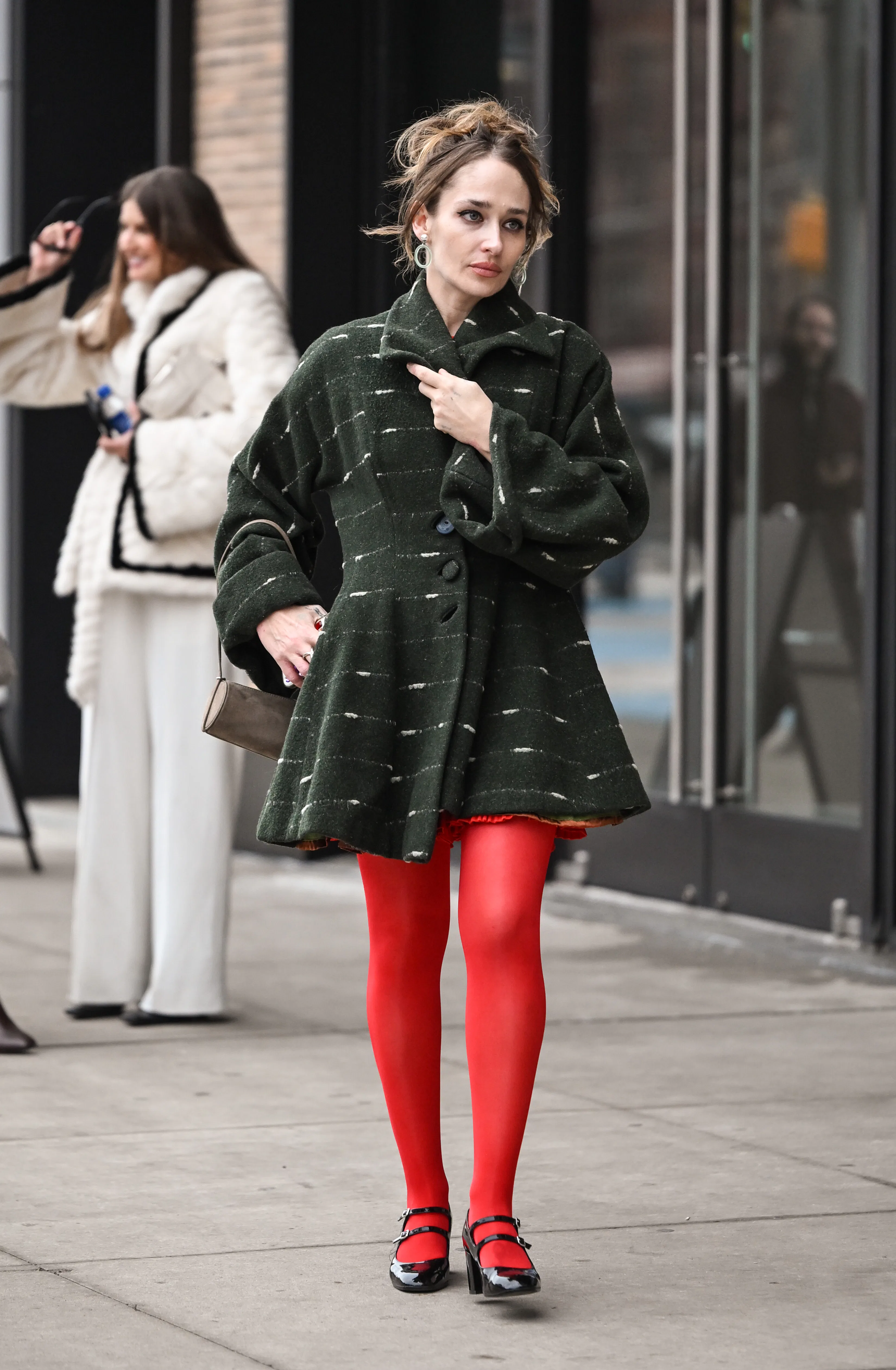 NEW YORK, NEW YORK - FEBRUARY 11: Jemima Kirke is seen wearing a green and white coat, tan purse and...