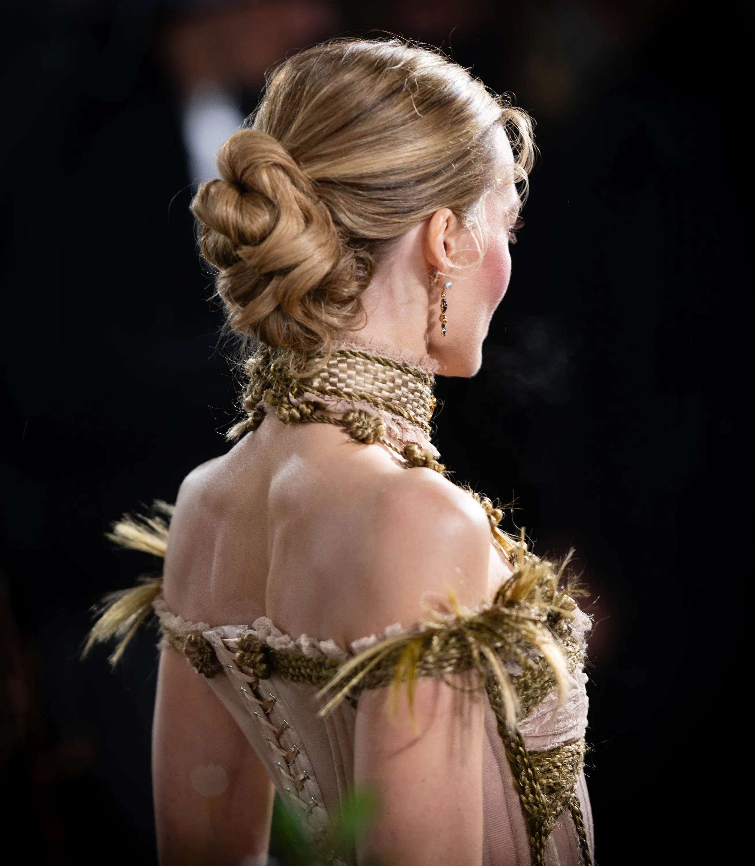 Margot Robbie wearing a serpentine knot hairstyle, viewed from the back