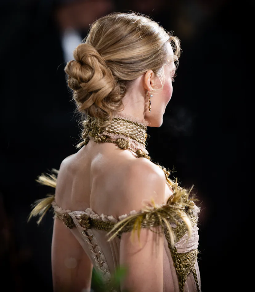 Margot Robbie wearing a serpentine knot hairstyle, viewed from the back