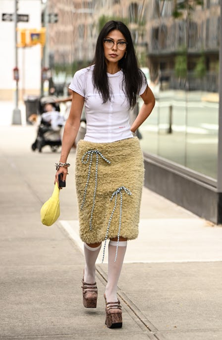 NEW YORK, NEW YORK - SEPTEMBER 16: A guest is seen wearing a white Eckhaus Latta t-shirt, yellow fau...