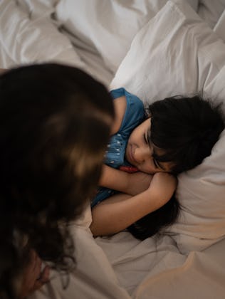 Mother taking care of daughter having a nightmare while sleeping