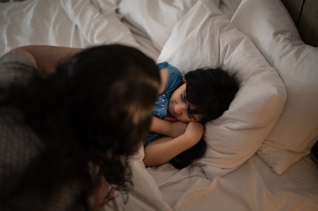 Mother taking care of daughter having a nightmare while sleeping