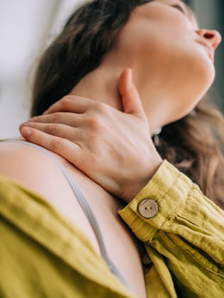 Close-up of woman with hand on sore neck for pain relief