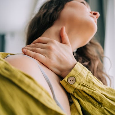 Close-up of woman with hand on sore neck for pain relief