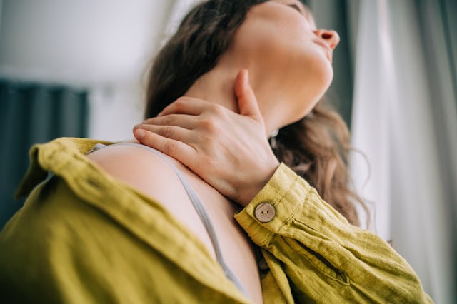 Close-up of woman with hand on sore neck for pain relief