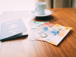 Candid shot of Swiss currency Francs on a hotel room table with authentic looking natural window lig...